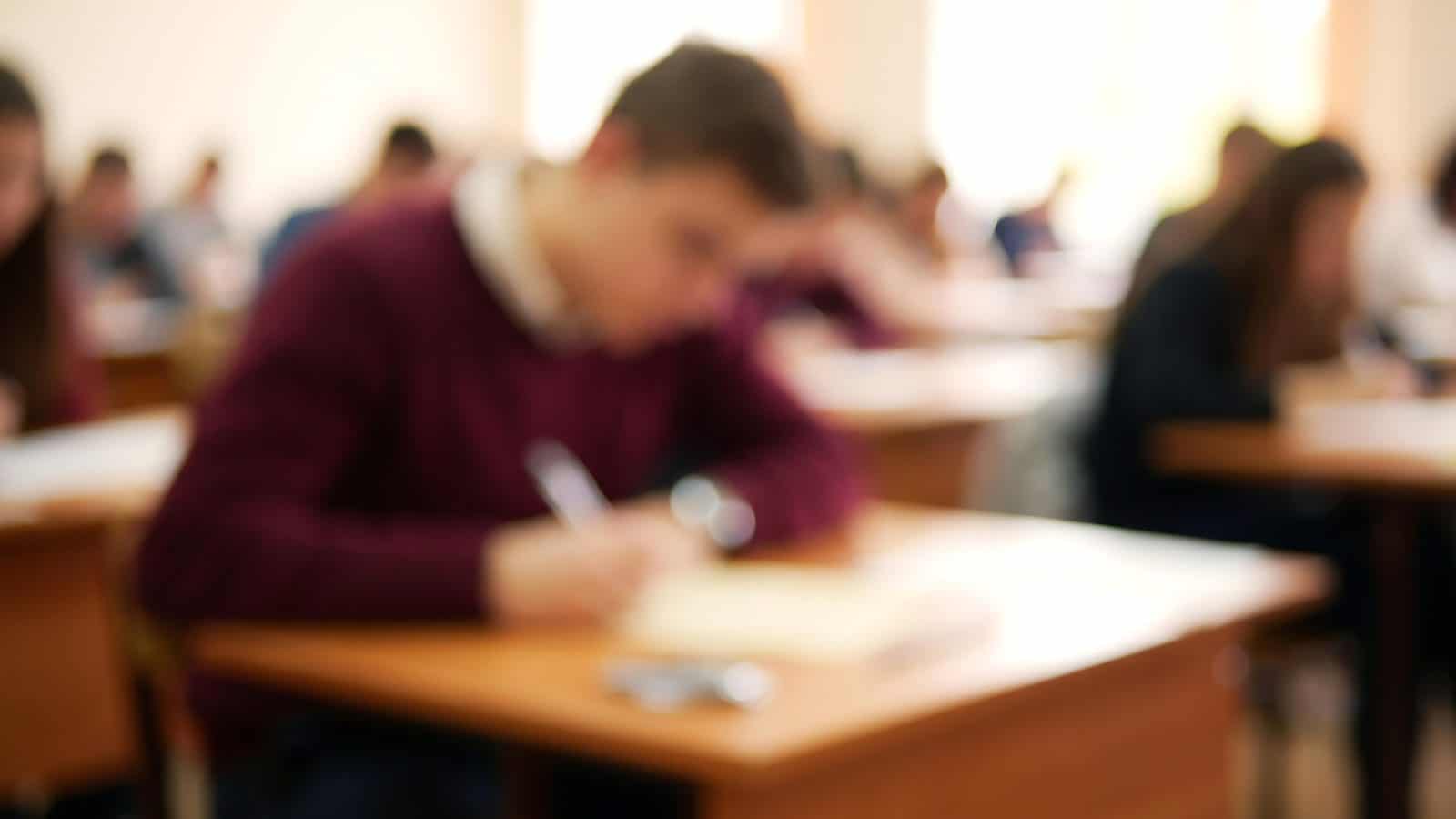 Jongeman worstelt met een opdracht in een klaslokaal, beeld bij Waarom blijf ik worstelen met dezelfde zonde